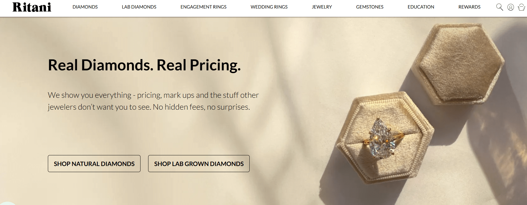 Ritani homepage banner showing a pear-shaped diamond engagement ring in a beige velvet ring box with the text “Real Diamonds. Real Pricing.” and buttons to shop natural or lab-grown diamonds.